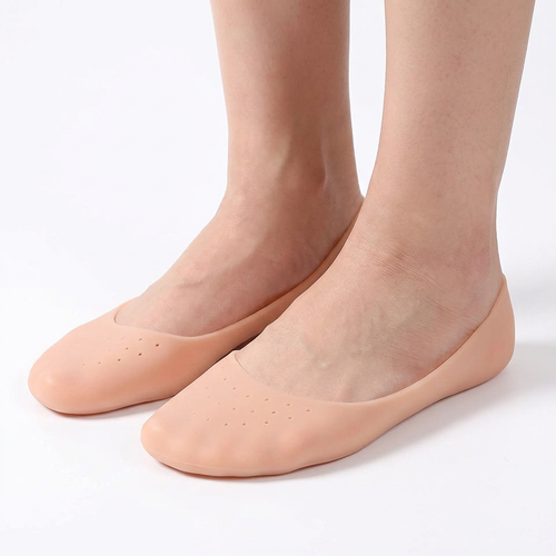 Adult feet wearing beige closed-toe perforated gel foot covers on a white background